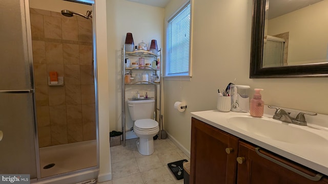 bathroom featuring a shower stall, baseboards, toilet, tile patterned floors, and vanity