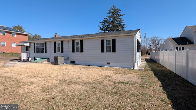 rear view of house featuring crawl space, cooling unit, a yard, and fence