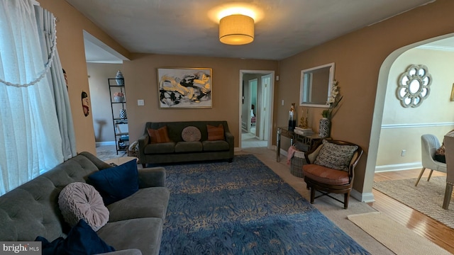 living room featuring arched walkways and baseboards