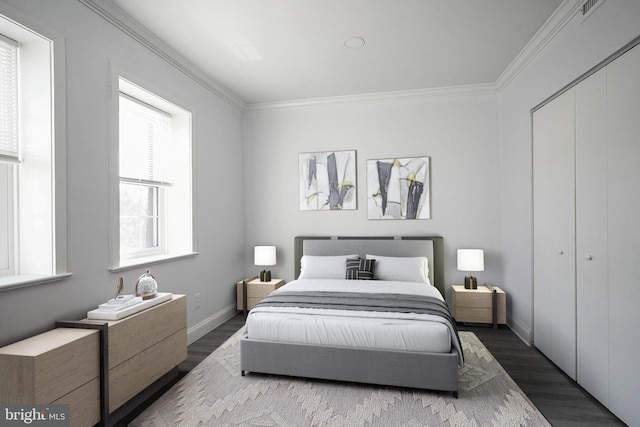 bedroom featuring dark wood finished floors, baseboards, crown molding, and a closet