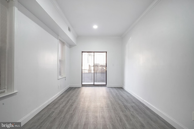 unfurnished room with visible vents, crown molding, baseboards, and wood finished floors