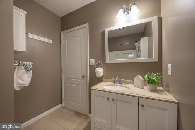 full bathroom with tile patterned flooring, vanity, a shower with shower curtain, and baseboards