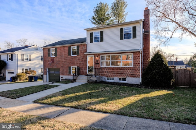 split level home with a front lawn, fence, concrete driveway, brick siding, and a chimney