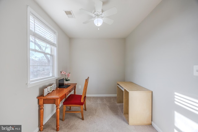 office featuring visible vents, light carpet, baseboards, and a ceiling fan