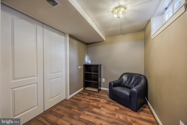 living area featuring wood finished floors, visible vents, and baseboards