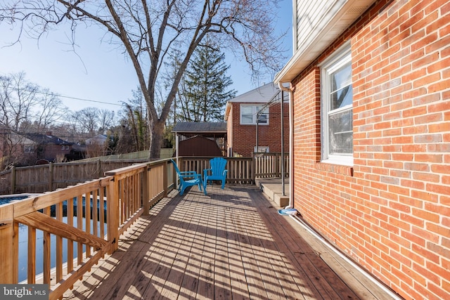 wooden terrace with a swimming pool and fence