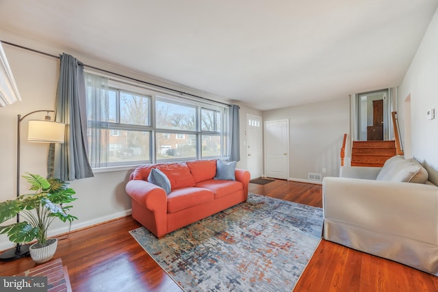 living area featuring visible vents, wood finished floors, and baseboards