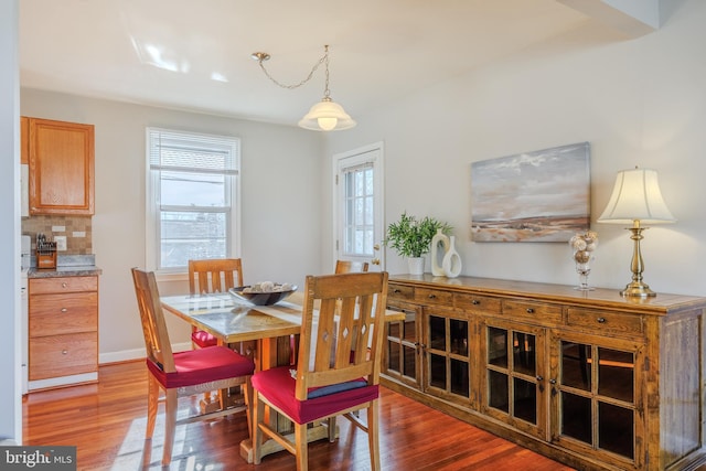 dining space featuring wood finished floors and baseboards