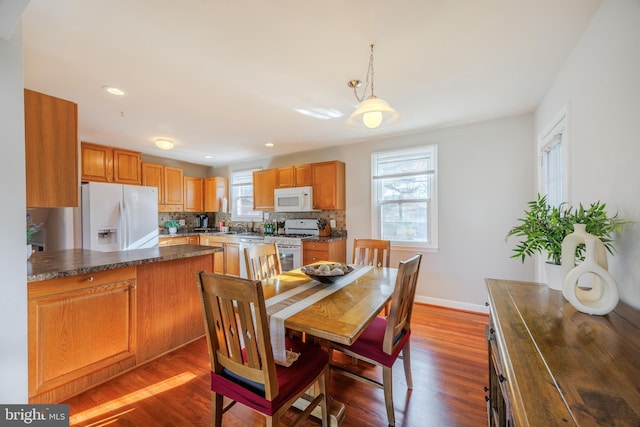 dining area featuring recessed lighting, baseboards, and wood finished floors