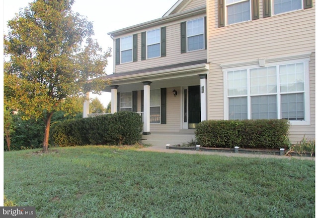 view of front of property with a porch and a front lawn