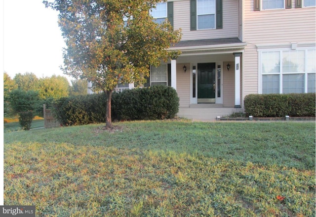 view of front of property featuring covered porch and a front lawn