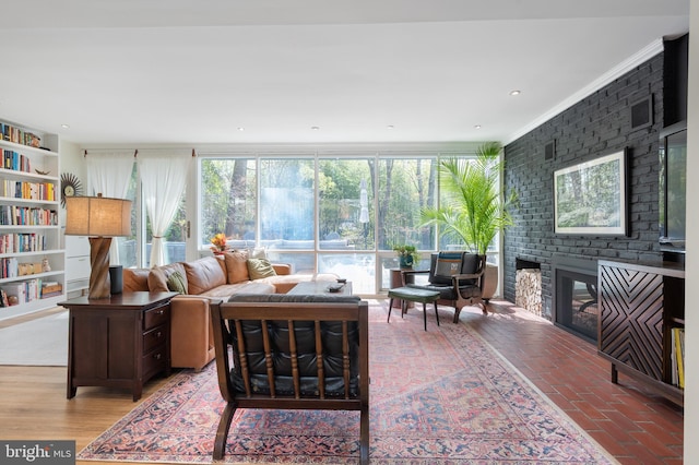 living area with brick floor, ornamental molding, and a fireplace