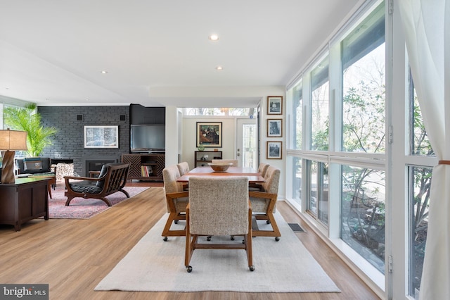 dining room featuring visible vents, recessed lighting, a fireplace, and wood finished floors