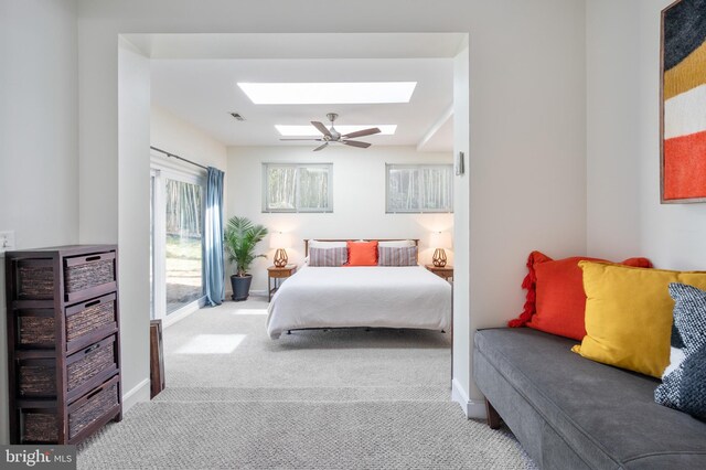 bedroom featuring a ceiling fan, baseboards, visible vents, a skylight, and carpet flooring