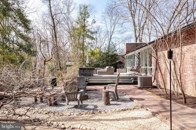 deck with central air condition unit, an outdoor living space, a patio, and a sunroom