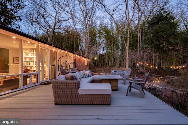 deck featuring an outdoor living space with a fire pit