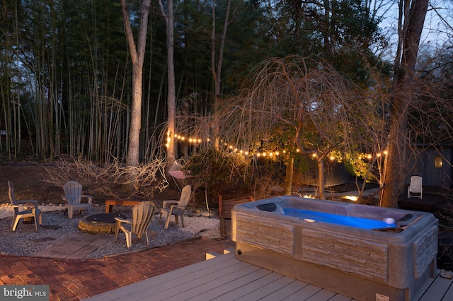 wooden terrace featuring an outdoor hot tub and an outdoor fire pit