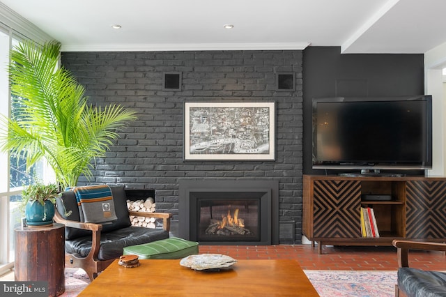 living room with a brick fireplace, plenty of natural light, and brick floor