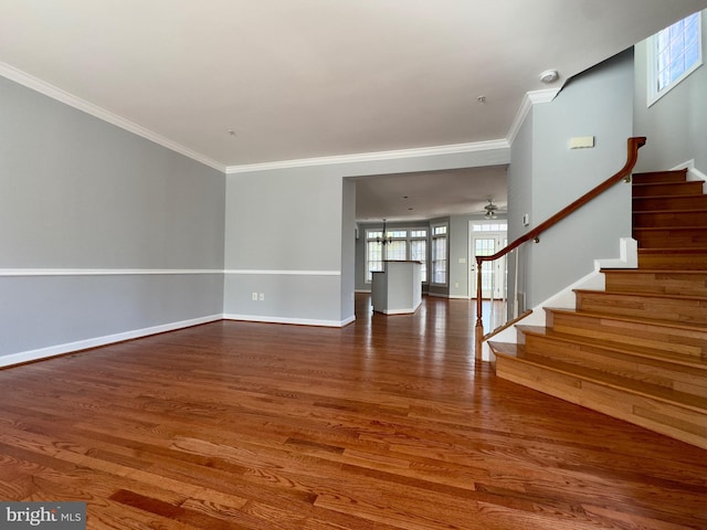 interior space featuring stairway, baseboards, wood finished floors, and crown molding