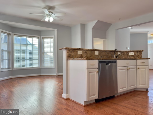 kitchen with white cabinets, light wood-style flooring, dishwasher, and dark stone counters