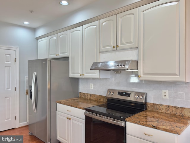 kitchen featuring range hood, backsplash, dark stone countertops, and appliances with stainless steel finishes