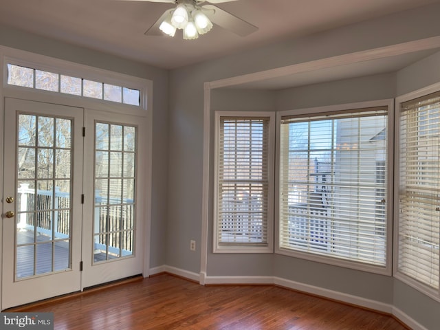 entryway featuring a ceiling fan, wood finished floors, and baseboards