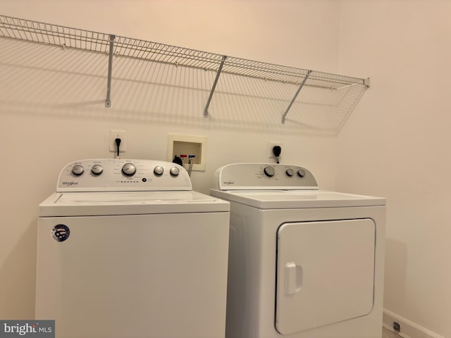 laundry area with laundry area, washer and dryer, and baseboards