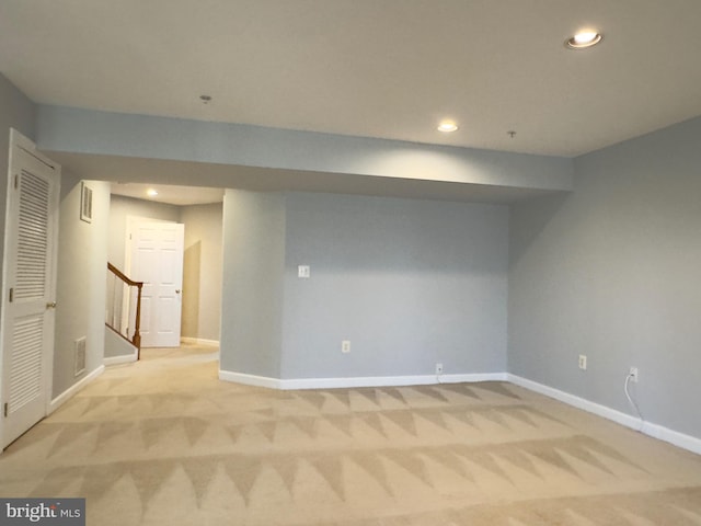 finished basement featuring recessed lighting, baseboards, light colored carpet, and stairs