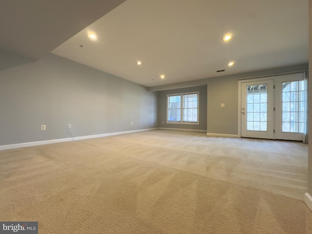 spare room with recessed lighting, baseboards, and light colored carpet