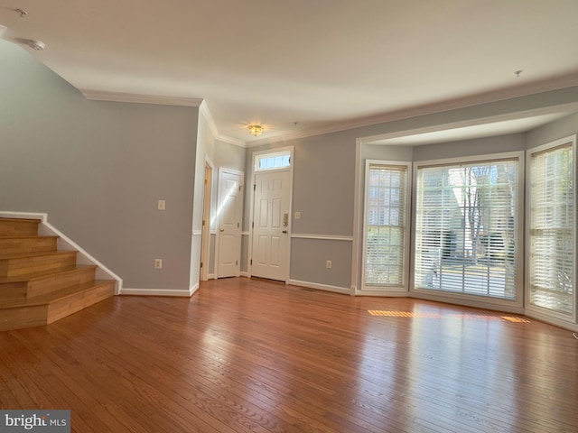 foyer with ornamental molding, stairs, baseboards, and hardwood / wood-style flooring