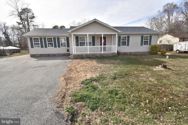 ranch-style home featuring crawl space, a front lawn, a porch, and driveway