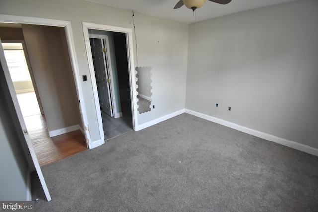 unfurnished room featuring baseboards, ceiling fan, and dark carpet