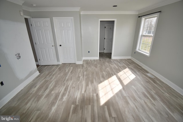 unfurnished bedroom with light wood finished floors, a closet, baseboards, and ornamental molding