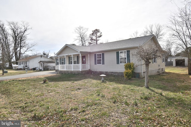 single story home featuring a porch, an outdoor structure, and a front lawn