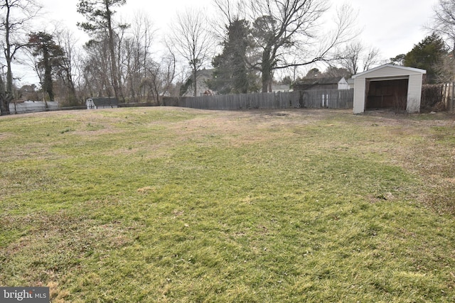 view of yard featuring a storage shed, an outbuilding, and fence