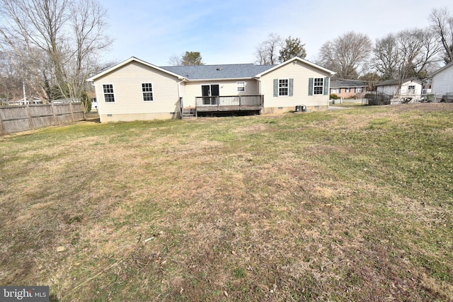 back of property with crawl space, a lawn, a wooden deck, and fence