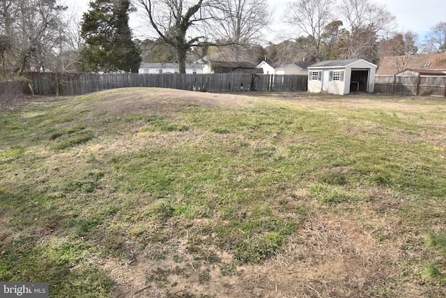 view of yard featuring a storage shed, an outbuilding, and a fenced backyard