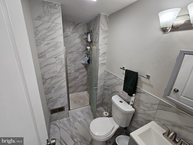 full bath with a sink, tile walls, marble finish floor, and a walk in shower