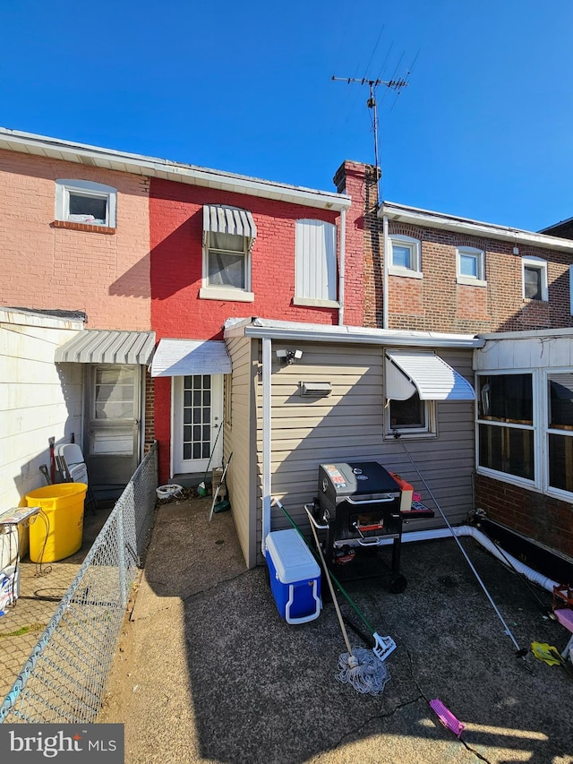 rear view of house with brick siding and a chimney