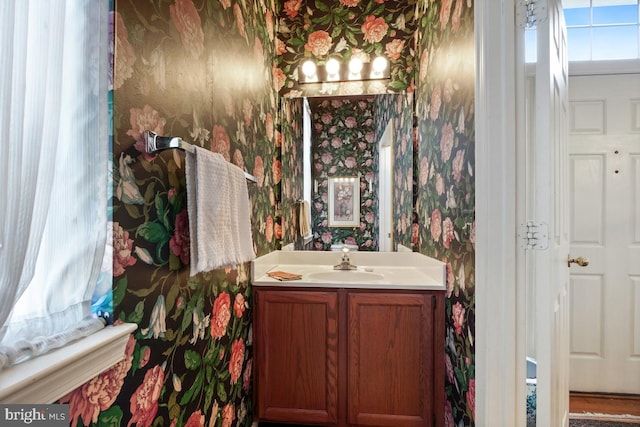 bathroom with wallpapered walls and vanity