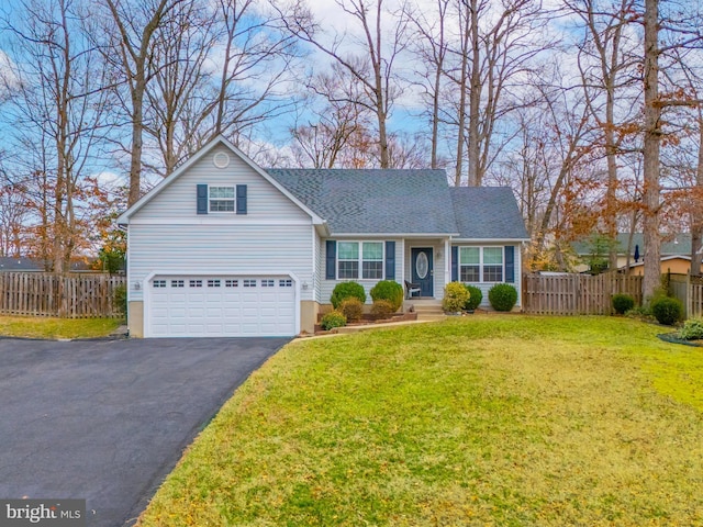 traditional-style house with a front lawn, fence, aphalt driveway, roof with shingles, and an attached garage