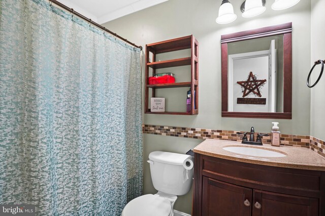 full bathroom with vanity, toilet, and tasteful backsplash