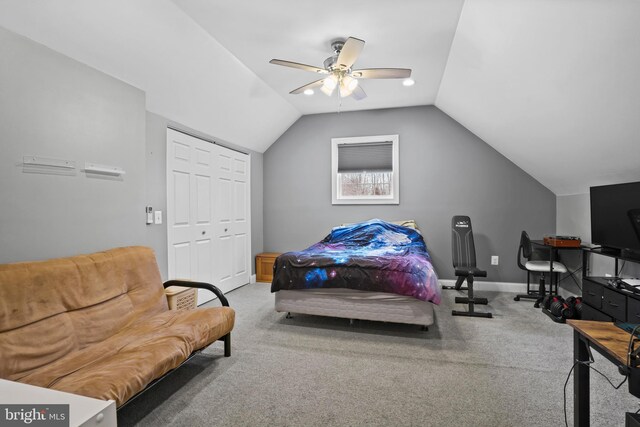 bedroom with baseboards, vaulted ceiling, carpet flooring, a closet, and a ceiling fan