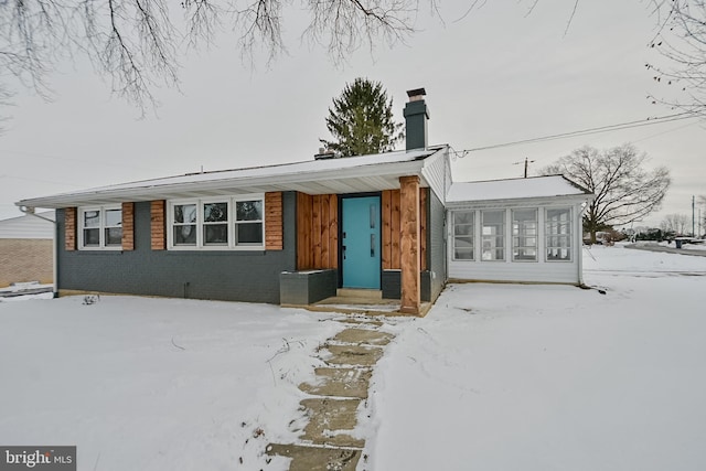 view of front of home with brick siding and a chimney