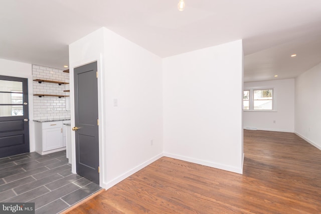 empty room featuring dark wood finished floors, recessed lighting, and baseboards