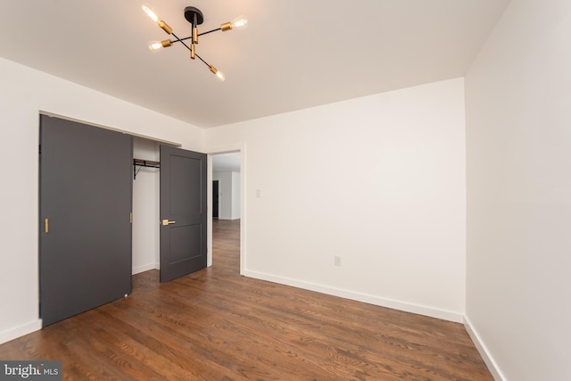 unfurnished bedroom featuring a closet, dark wood-type flooring, and baseboards