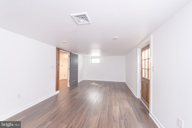 unfurnished room featuring dark wood finished floors, baseboards, and visible vents