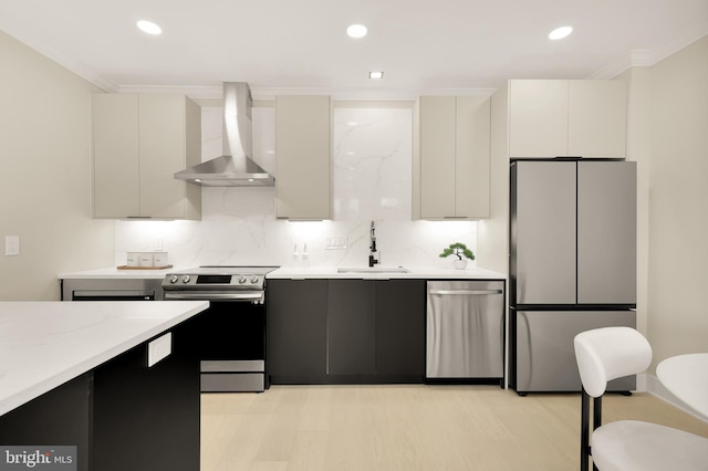 kitchen featuring a sink, tasteful backsplash, stainless steel appliances, wall chimney exhaust hood, and light countertops