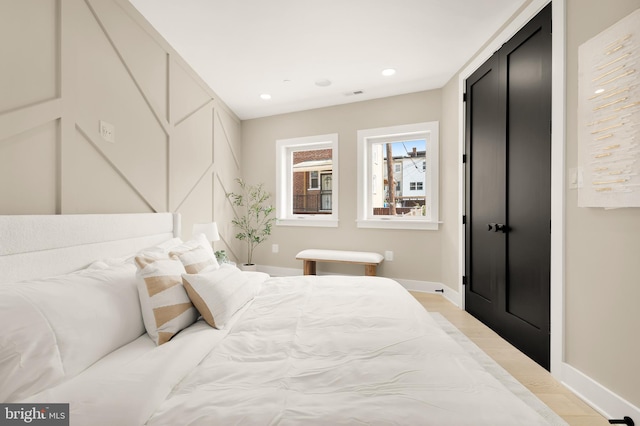 bedroom featuring recessed lighting, light wood-style floors, and baseboards