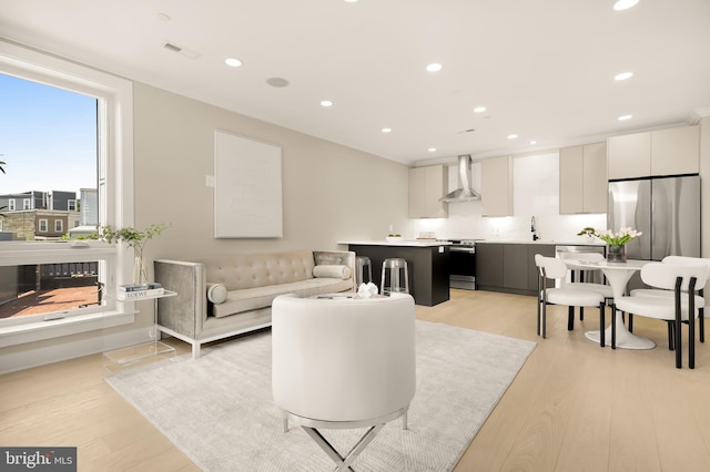 living area featuring light wood finished floors, visible vents, recessed lighting, and a fireplace